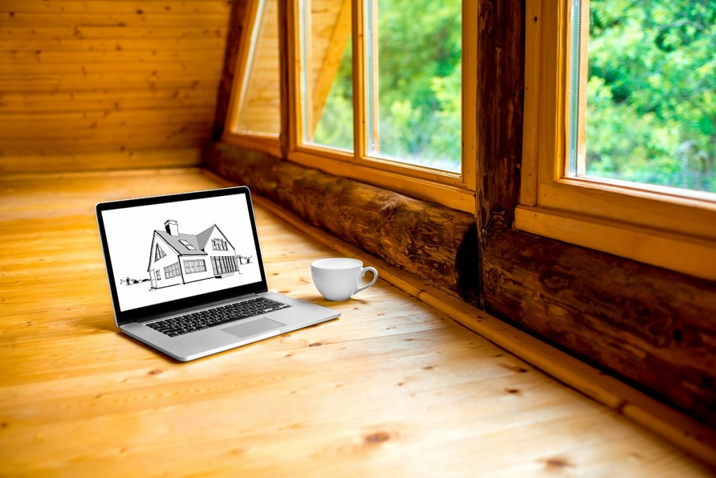 Laptop with drawing and coffe cup on the wooden floor near the window in the cottage
